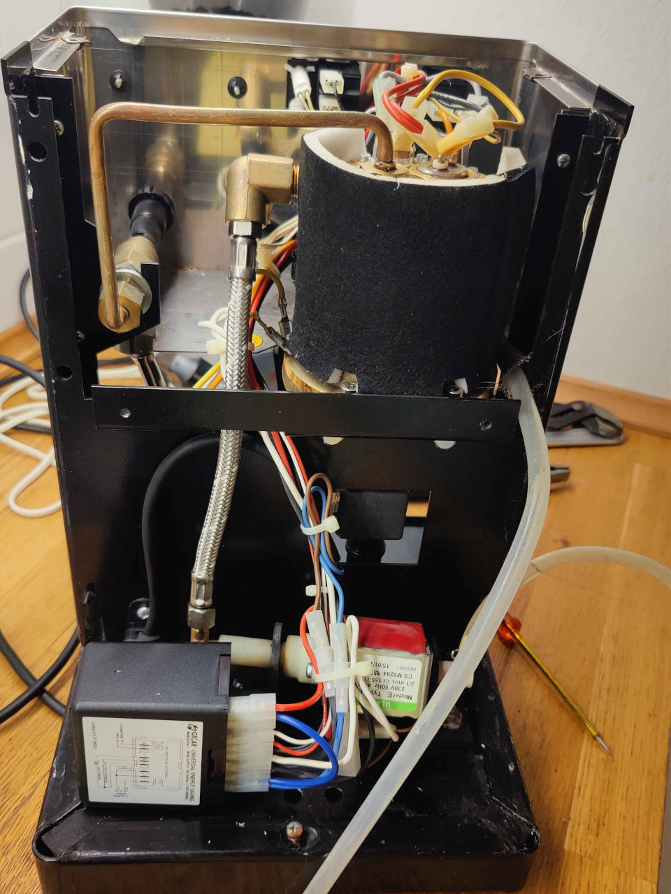 Back view of a Rancilio Silvia espresso machine with the back panel removed and all inner components visible