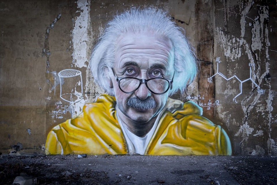 Photo of a spray painted mural of Albert Einstein in a yellow jacket